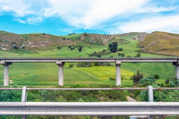Suportes de viaduto de ponte rodoviária no vale entre a infraestrutura de transporte de colinas verdes