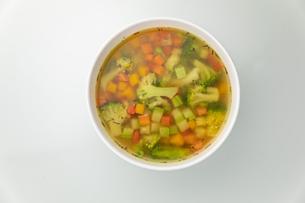 Suppe in einem weißen Teller und einem weißen Tisch