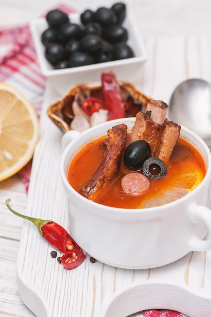 Suppe mit geräuchertem Fleisch, Oliven und Zitrone. Soljanka-Suppe