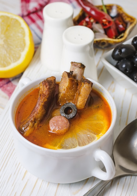 Suppe mit geräuchertem Fleisch, Oliven und Zitrone.