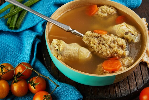 Suppe mit Matzenknödel und Hühnchen mit Karotten und Tomaten. Gesundes Essen für Pessach.