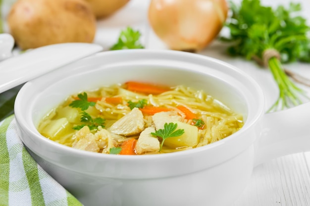 Suppe mit Nudeln und Huhn in einer weißen Keramikschale