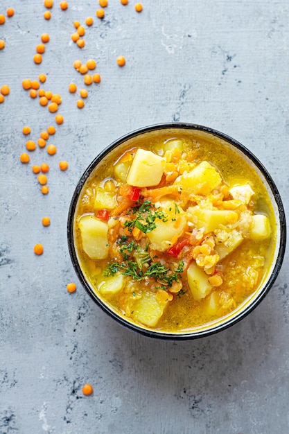 Suppe mit roten Linsen und Gemüse in einer Schüssel auf blauem Hintergrund.Traditionelles türkisches Gericht