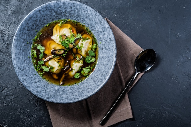 Suppe Wonton Hühnerbrühe mit Pilzen und Kräutern