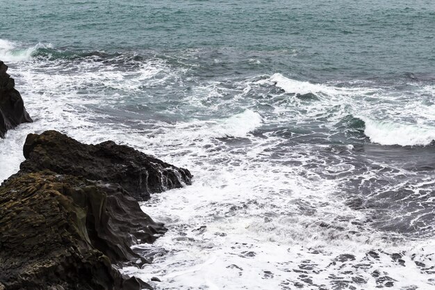 Surf na costa rochosa do oceano atlântico na islândia