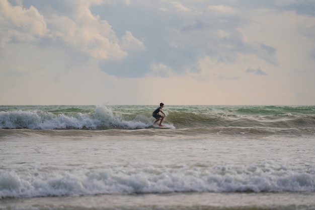 Una con un surf en sus manos en la orilla del mar