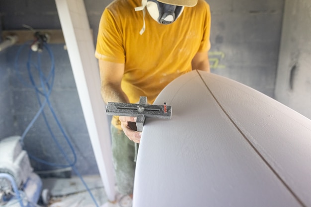 Surfboard-Modellierungs-Workshop-Mann perfektioniert die Modellierung eines Surfboard-Shaper-Konzepts