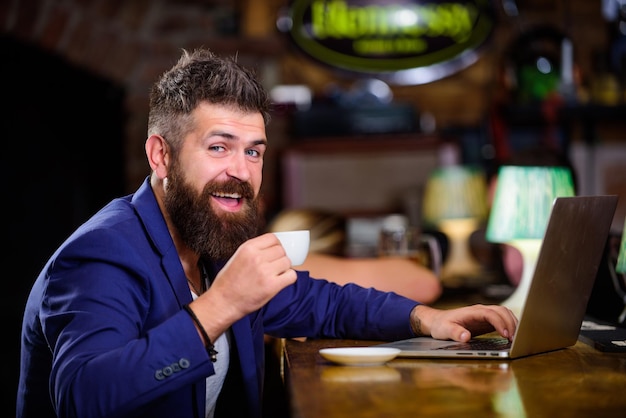 Surfen im Internet Man bärtiger Geschäftsmann sitzen Kneipe mit Laptop und Tasse Kaffee