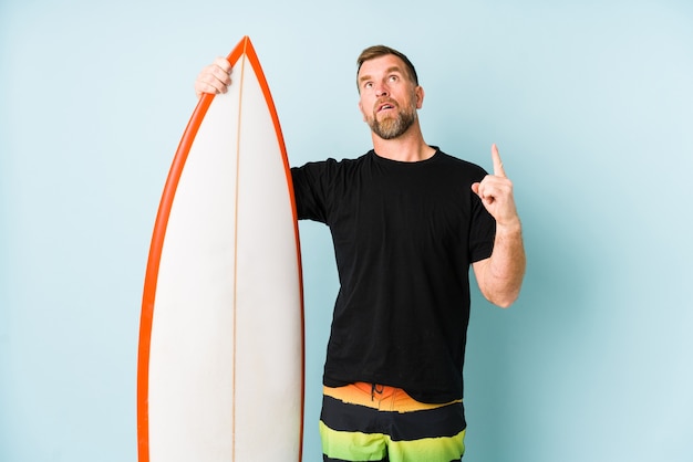 Surfener Mann lokalisiert auf blauem Hintergrund, der oben mit geöffnetem Mund zeigt.