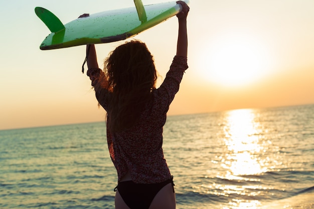 Surfer girl surf mirando al mar playa puesta de sol
