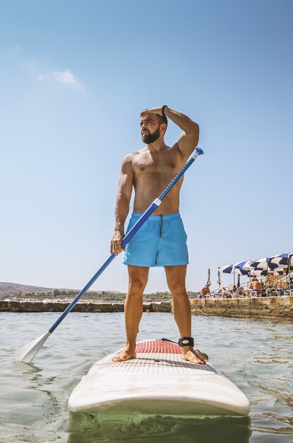 Surfer stehen oben auf paddelbrett auf meer