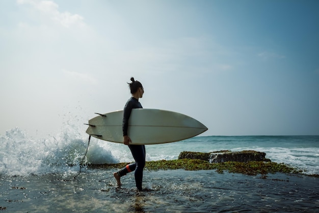 Surferin mit einem Surfbrett, die am Meer surfen will