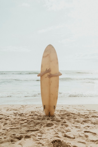 Surfista abrazando una maqueta de tabla de surf