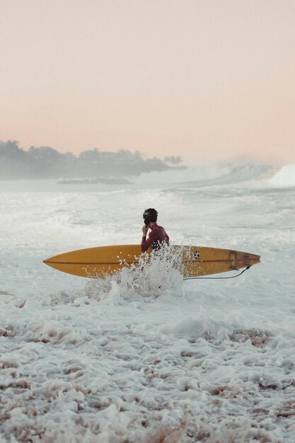 Surfista en el agua con sus tablas de surf