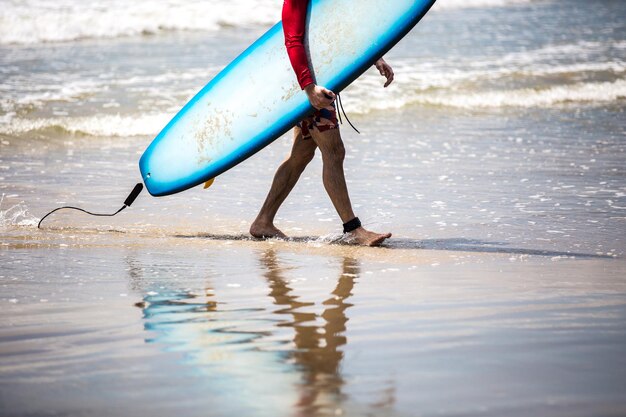 Surfista caminando por la playa