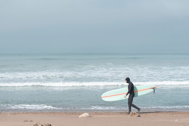 surfista caminando por la playa