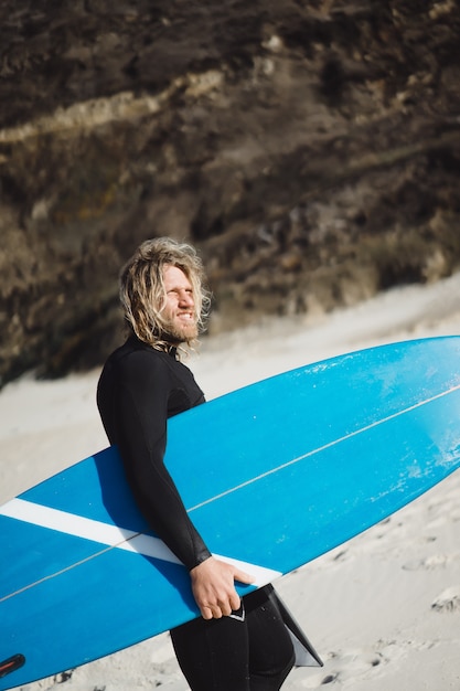 surfista com nadadeiras e um bodyboard em um terno hidráulico na costa do oceano