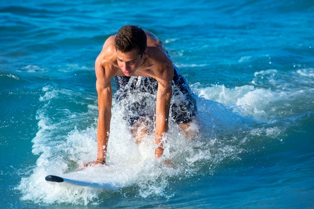 Surfista do menino surfando ondas na praia