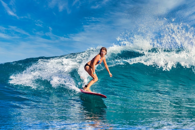 Surfista em uma onda azul em um dia ensolarado