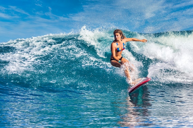 Surfista em uma onda azul em um dia ensolarado