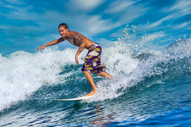 Surfista em uma onda azul em um dia ensolarado