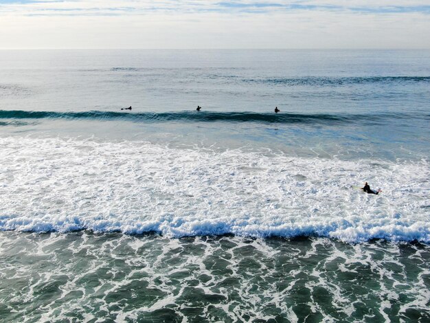 Un surfista está en el agua y el agua lleva una camiseta negra.