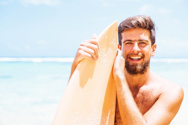 Surfista guapo en una playa