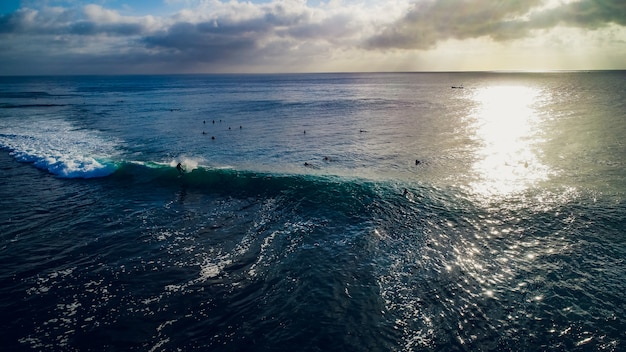 Surfista en olas en el océano al atardecer, vista superior