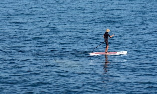 Surfista remando em sua prancha