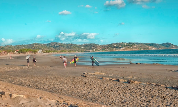 Surfistas caminando por la playa imagen de surfistas con su tabla de surf caminando sobre la arena