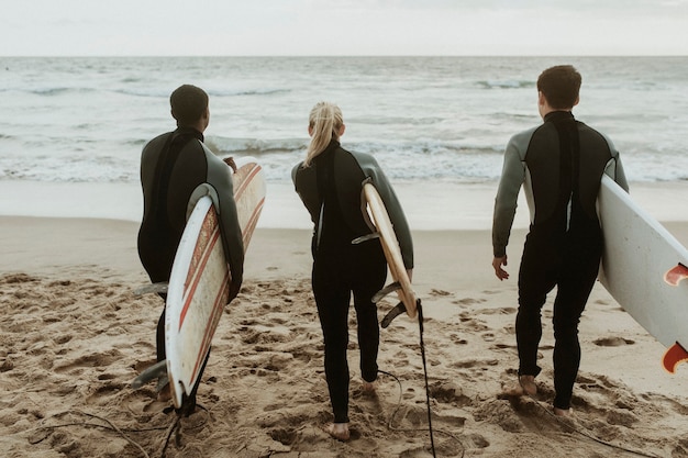 Foto surfistas correndo em direção ao mar