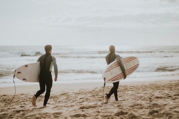 Surfistas correndo na praia