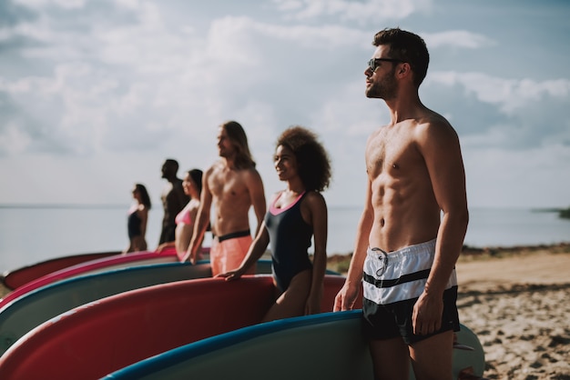 Surfistas em trajes de banho em pé na praia,