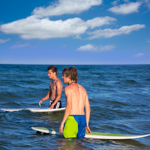 Surfistas esperando las olas en la playa.