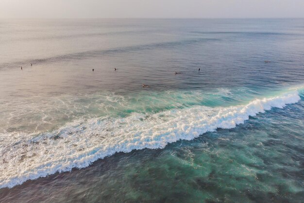 Surfistas nas ondas na vista superior do oceano