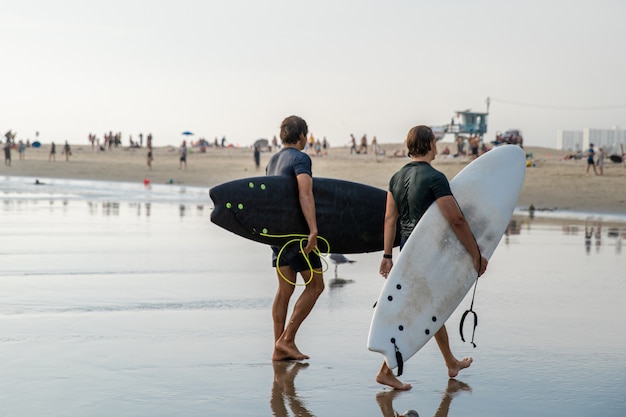 Los surfistas regresan del océano después de surfear activamente en las olas.