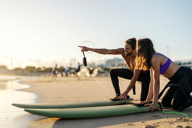 Los surfistas señalan y miran las olas.