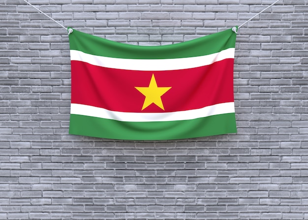 Surinam-Flagge, die an der Backsteinmauer hängt