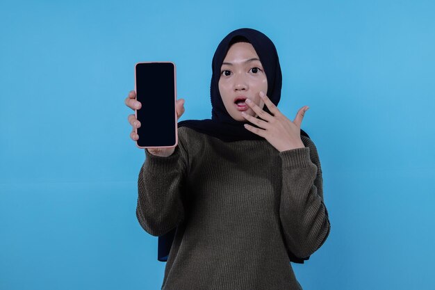 Surpreendente jovem asiática vestindo uma camiseta vermelha longa segurando um telefone celular