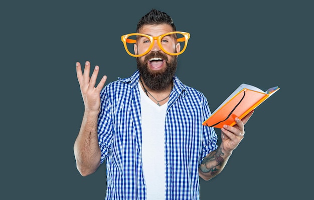 Foto surpreendido homem com barba engraçado com óculos de festa lendo um livro