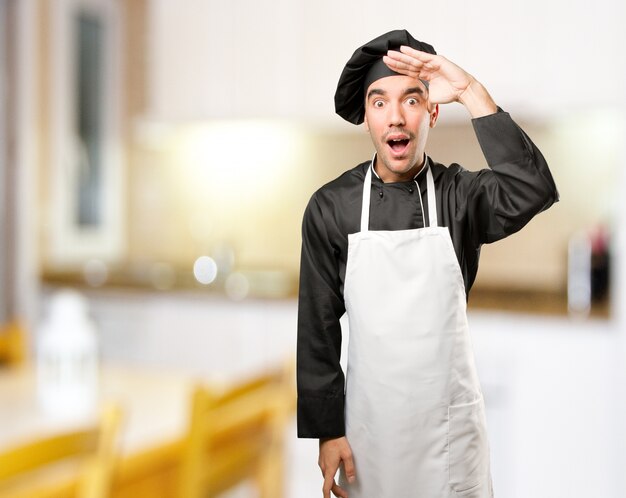 Surpreendido jovem cozinheiro com um gesto de observação