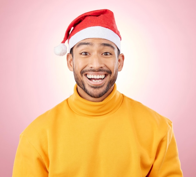 Surpresa de retrato e homem feliz com chapéu de Natal divertido e festivo para férias em fundo rosa Choque de felicidade e modelo animado com chapéu de Papai Noel sorridente e moda de férias de inverno no estúdio