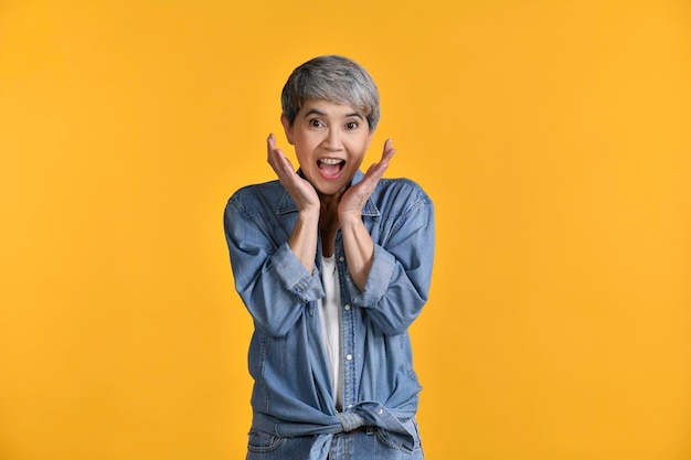 Surpresa feliz mulher asiática de meia-idade, 50 anos, gritando sobre o fundo colorido Olhando e sorrindo para a câmerax9