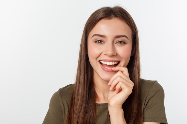 surpresa mulher excitada olhando para o lado. Jovem feliz surpresa, olhando de soslaio em emoção. Raça mista asiático e branco modelo feminino caucasiano em cinza.