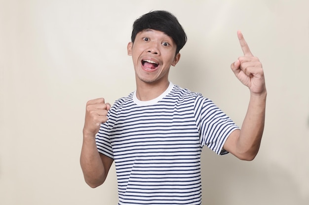 Surpreso e chocado jovem asiático vestindo camiseta listrada