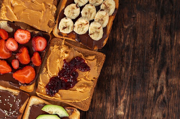 Surtido de bocadillos dulces con pasta de chocolate, pasta de maní y rodajas de fruta.