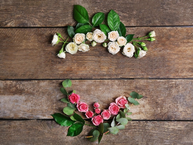 Surtido de cabezas de rosas sobre fondo de madera