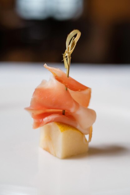 Surtido de canapés en mesa de madera Servicio de banquetes Comida de catering Aperitivos con queso Jamón Prosciutto y fruta Aperitivos para buffet en la recepción Menú de banquetes de catering decorado