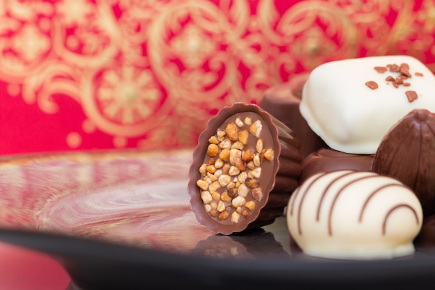 Surtido de caramelos de chocolate gourmet en diferentes formas y colores en el plato.
