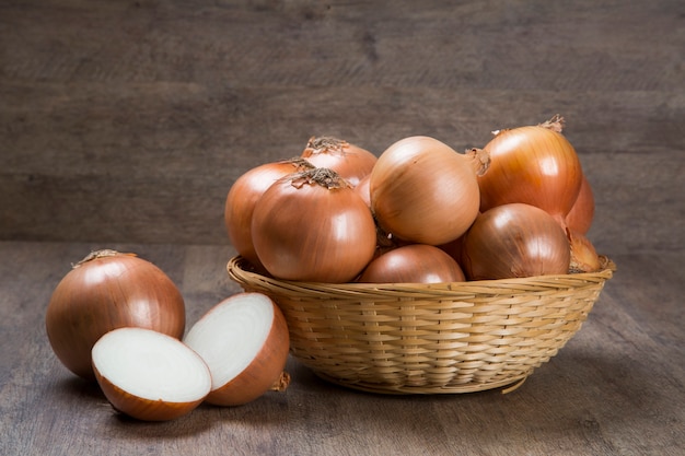 Surtido de cebollas frescas de granja en una mesa de madera rústica con cebolletas